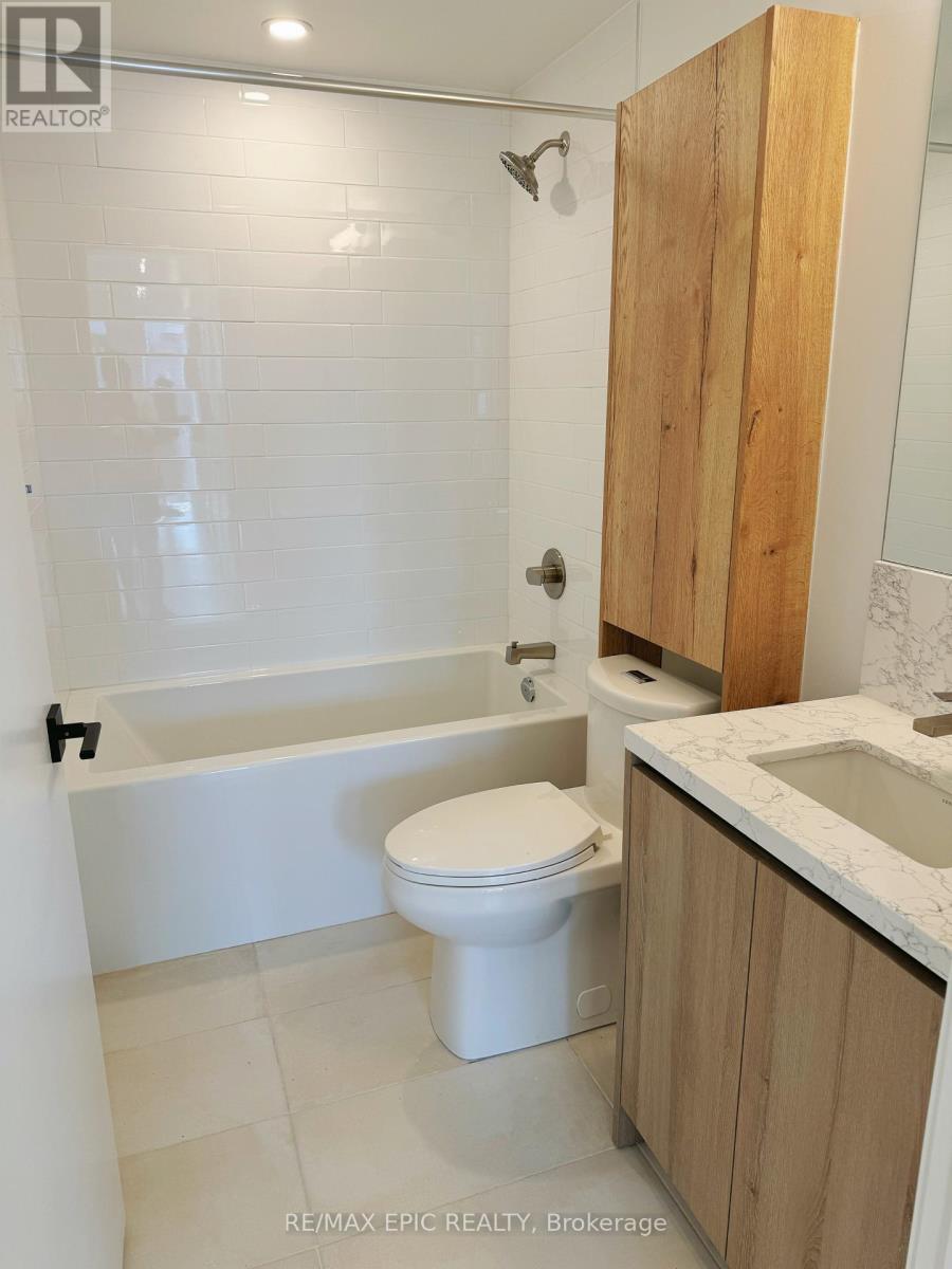 A white toilet sits in a bathroom next to a bathtub.