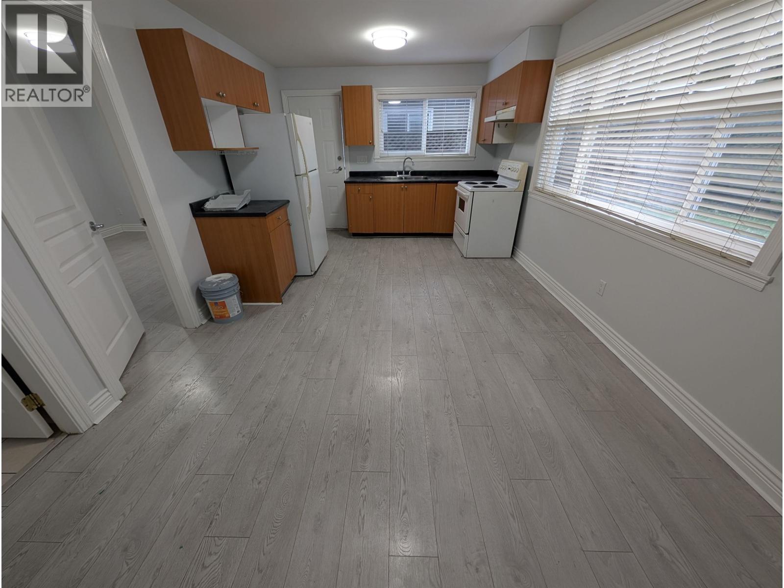 A kitchen with wood floors and white walls.