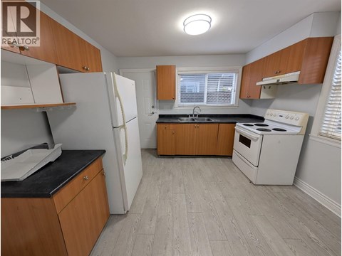 A kitchen with wooden cabinets and a white refrigerator.