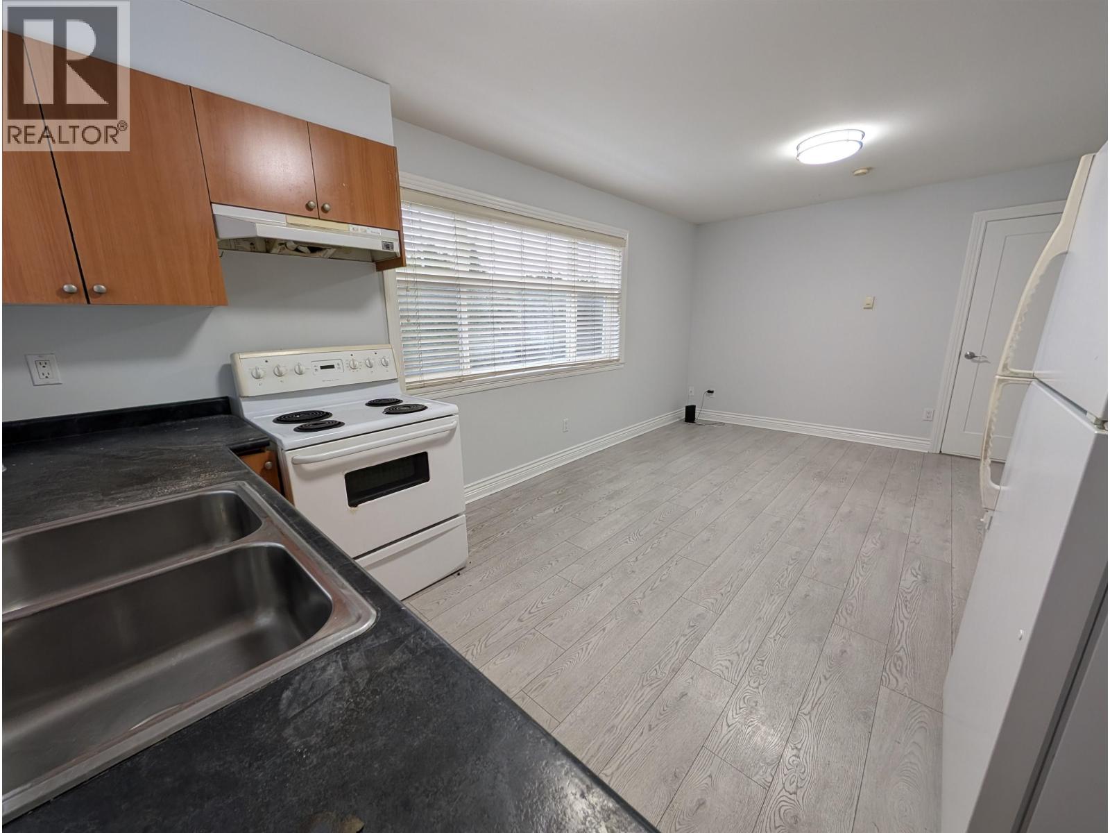 A kitchen with a stove top oven and a sink.