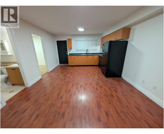 A kitchen with wooden floors and black appliances.