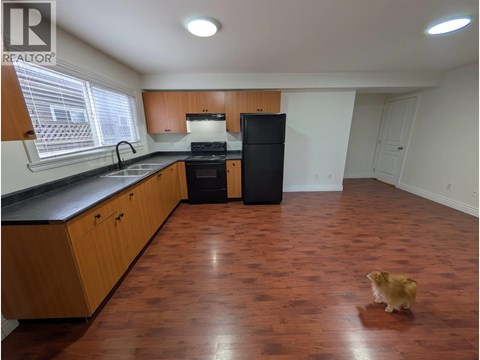 A kitchen with wooden cabinets and black countertops.