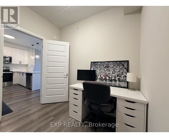 A white office space with a desk, chair, and a television on the wall.