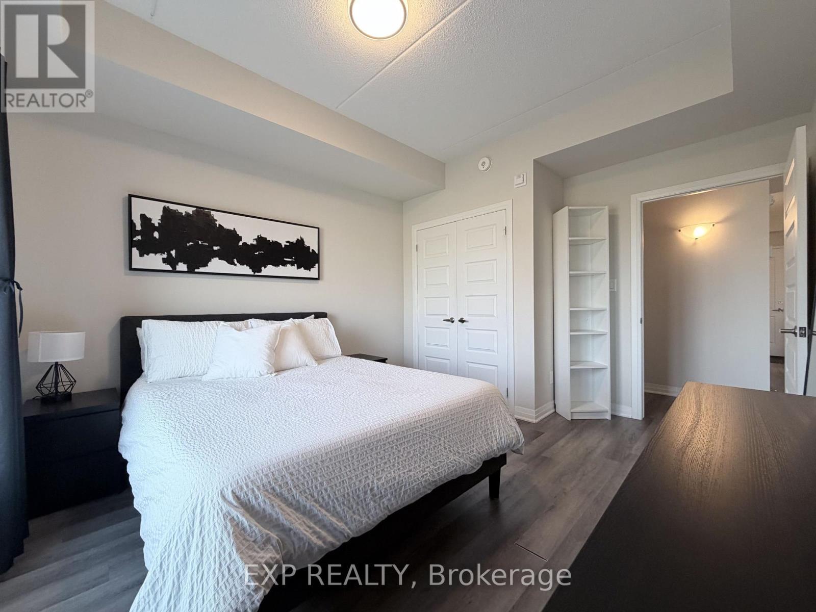 A bedroom with a large bed and a painting on the wall.