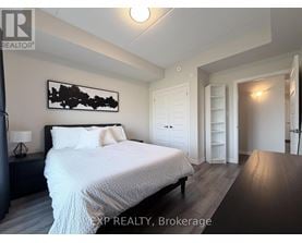 A bedroom with a large bed and a painting on the wall.