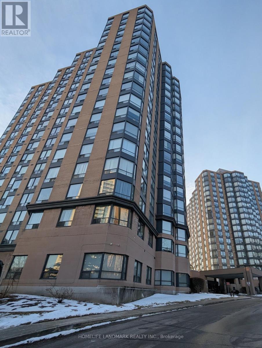 A tall building with a glass facade stands next to a shorter building with a brick facade.
