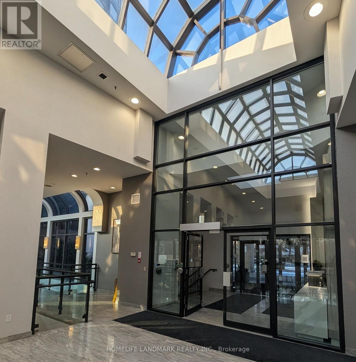 A glass door entrance to a building with a glass ceiling.