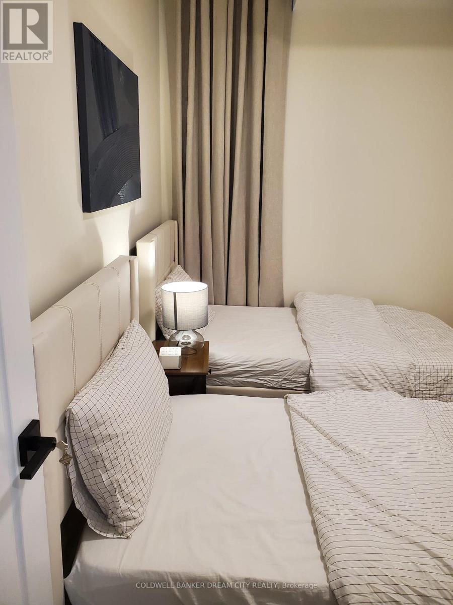 A bedroom with a bed, pillow, and lamp.