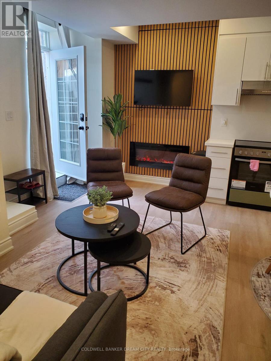 A living room with a fireplace and a television mounted above it.