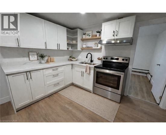 A kitchen with white cabinets and a stainless steel oven.