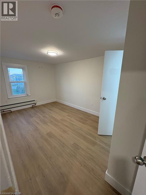 A room with wooden flooring and a window.
