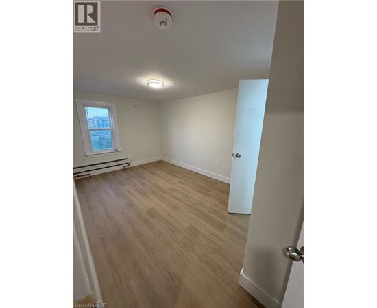 A room with wooden flooring and a window.