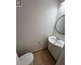 A white toilet sits next to a sink in a small bathroom.