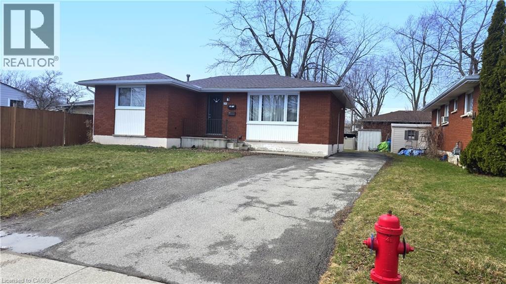 A red fire hydrant is in front of a house.