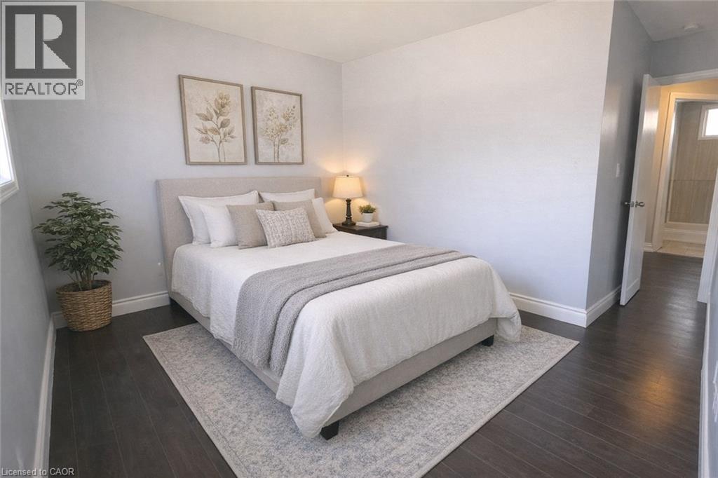 A bedroom with a large bed and a potted plant.