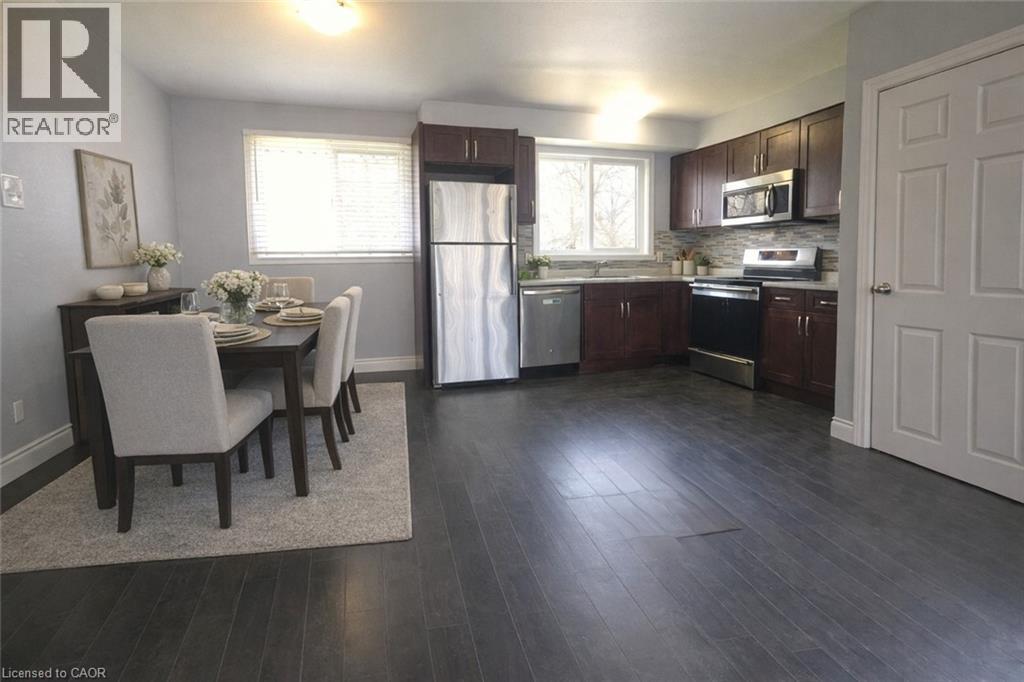A kitchen with dark wood floors and white walls.