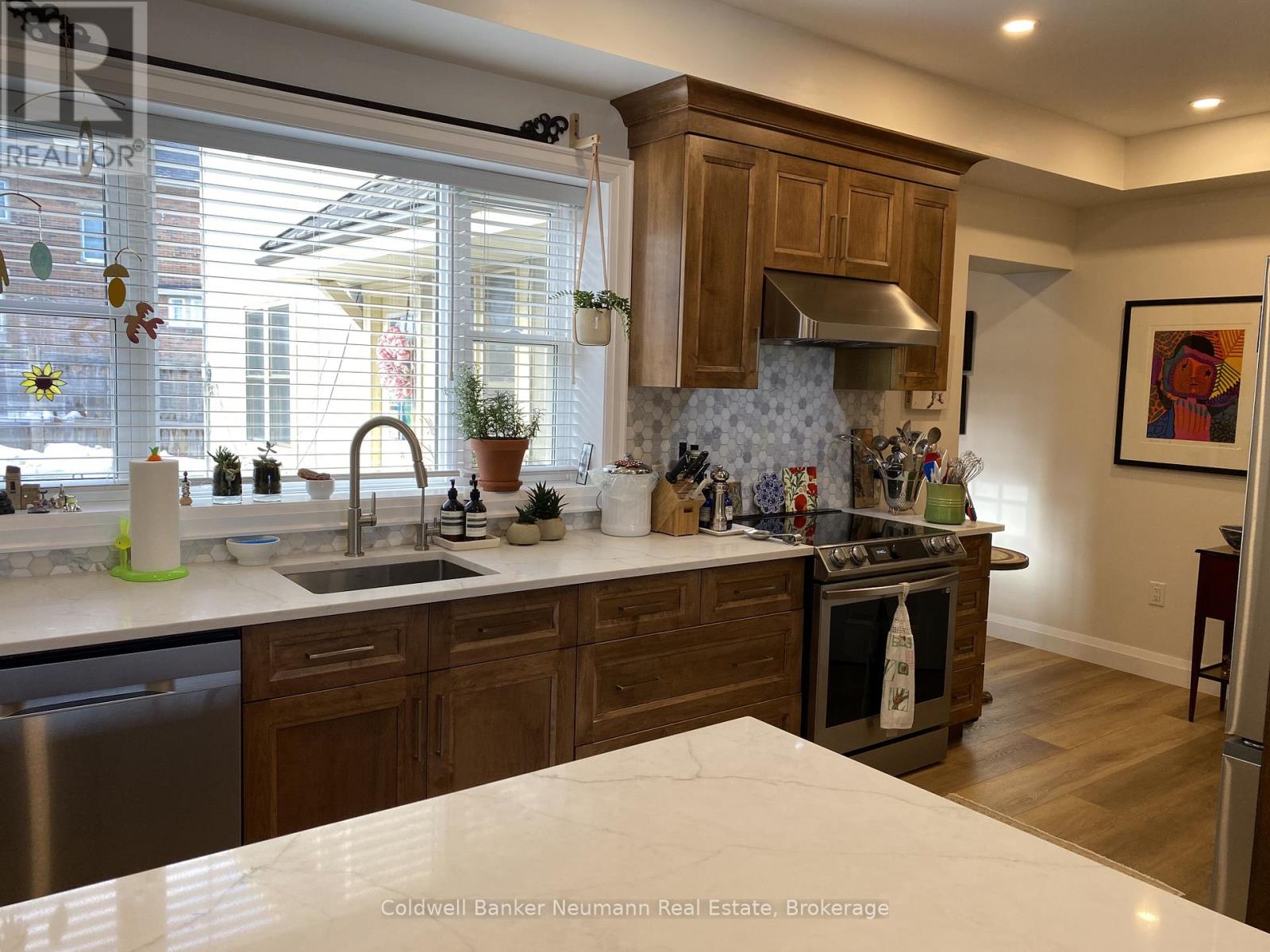 A kitchen with wooden cabinets and a stainless steel dishwasher.