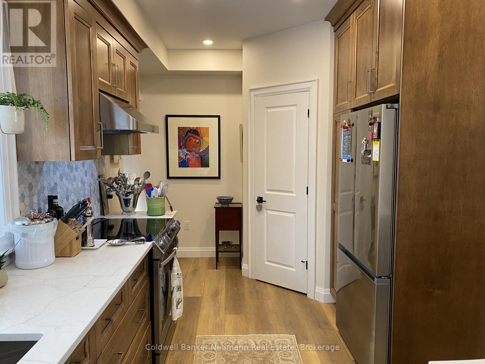 A kitchen with wooden cabinets and a fridge.