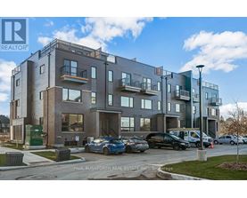 A modern apartment building with cars parked in front.
