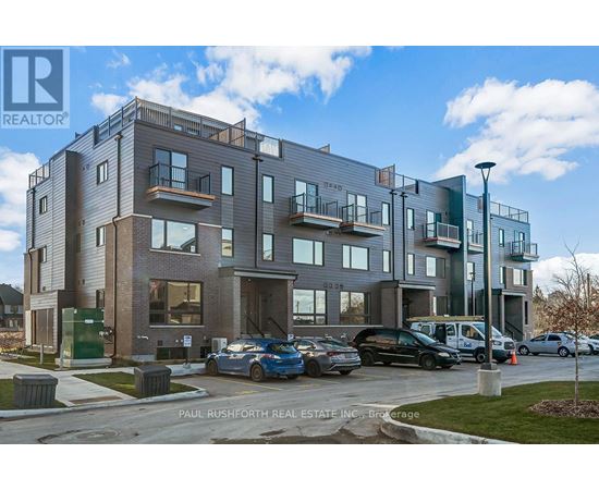 A modern apartment building with cars parked in front.