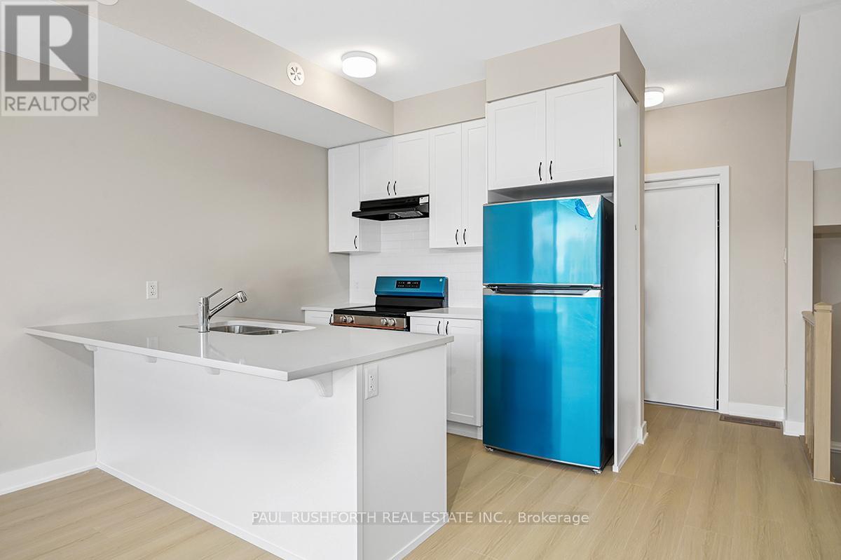 A kitchen with a white counter and a blue fridge.