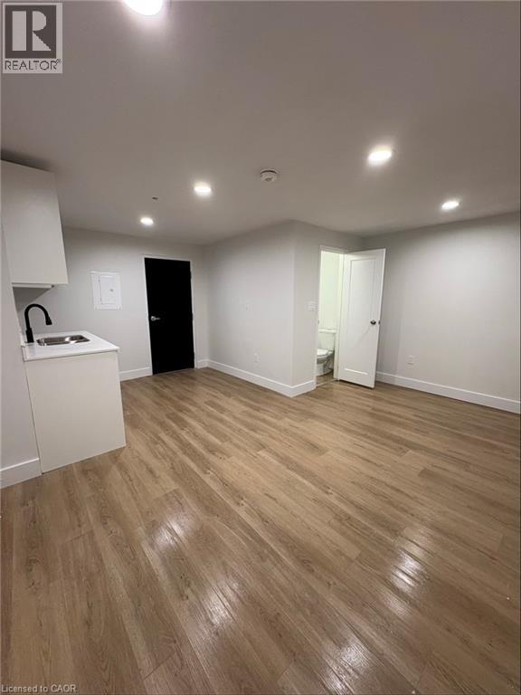 A room with wooden flooring and white walls.