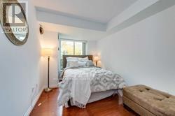 A bedroom with a bed and a bench.