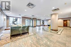 A spacious lobby with a marble floor and a green sofa.