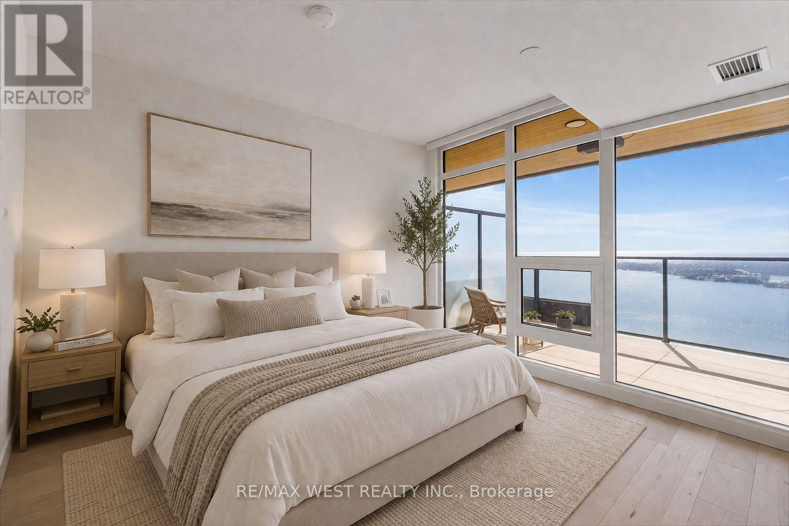 A bedroom with a large bed and a view of the ocean through the window.