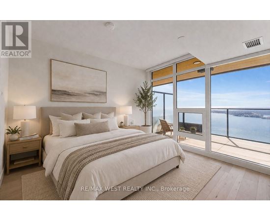 A bedroom with a large bed and a view of the ocean through the window.