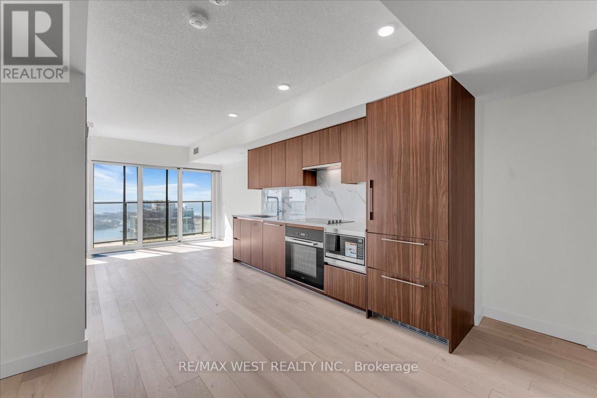 A modern kitchen with wooden cabinets and a stainless steel refrigerator.