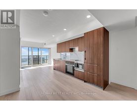 A modern kitchen with wooden cabinets and a stainless steel refrigerator.