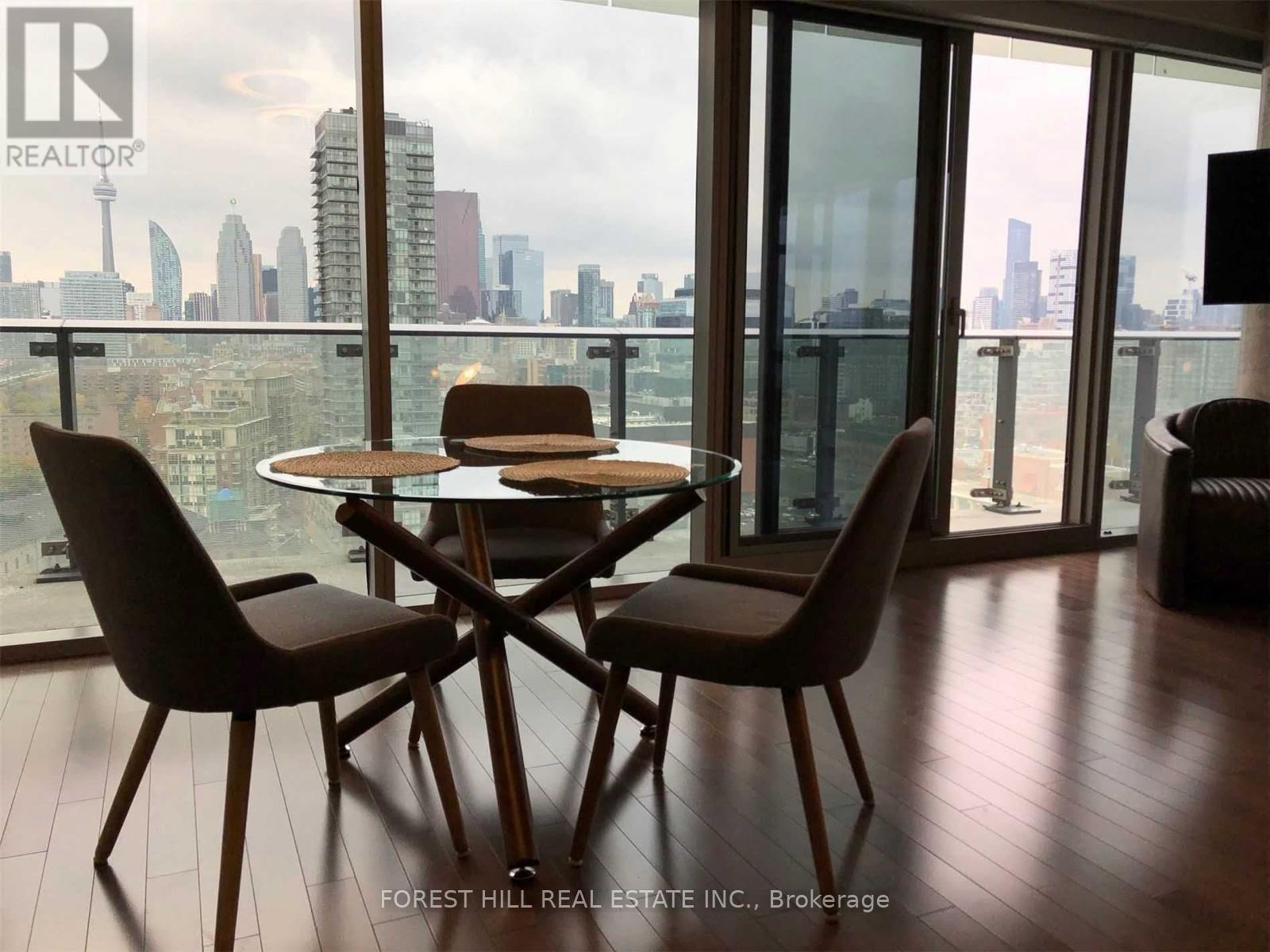 A dining room with a table and chairs overlooking a city skyline.