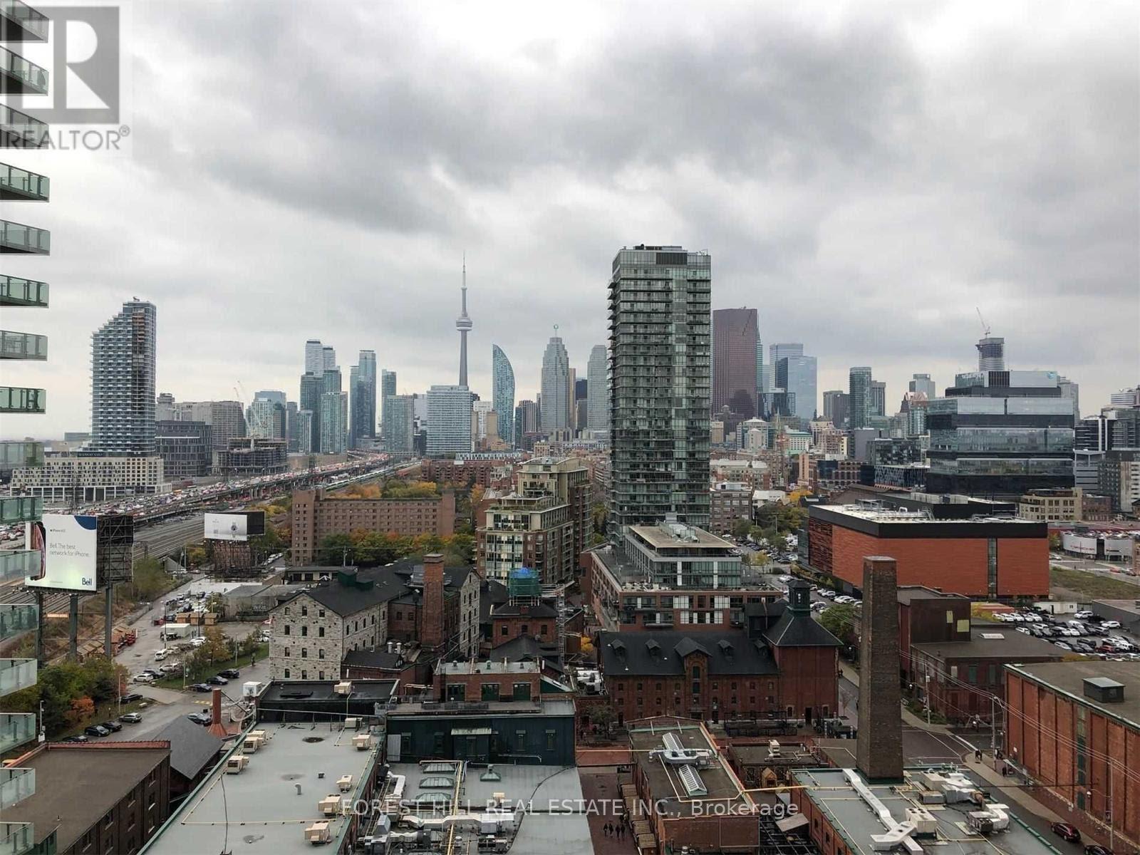 A cityscape with a mix of modern and older buildings, with a cloudy sky overhead.