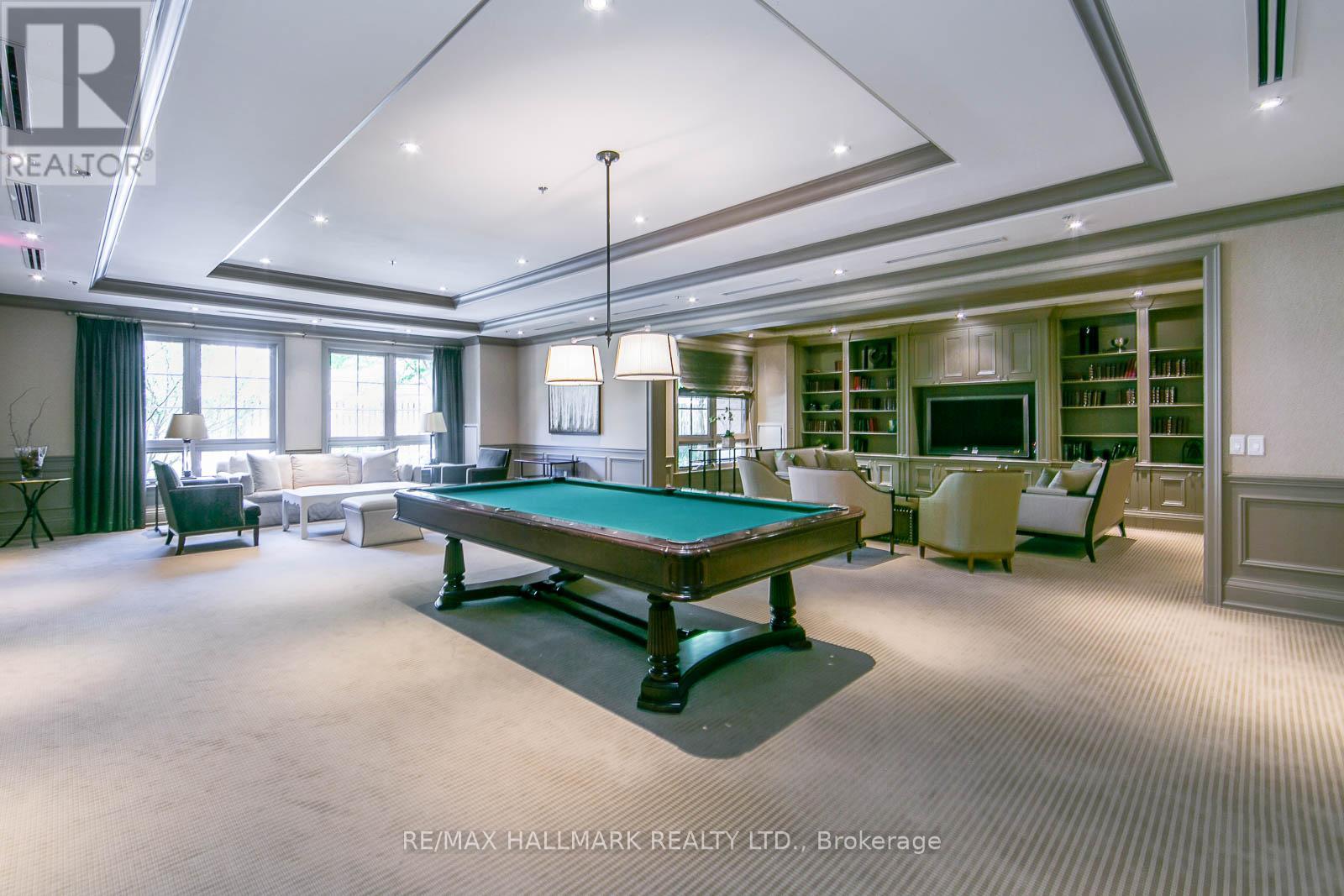 A large room with a pool table and a television.