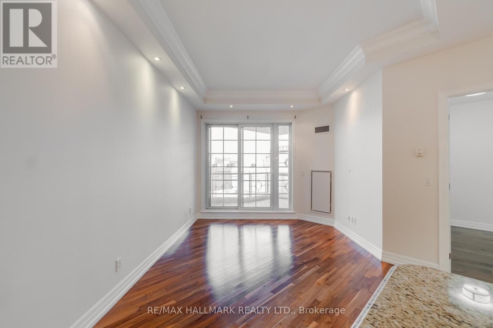 A spacious room with a wooden floor and white walls.