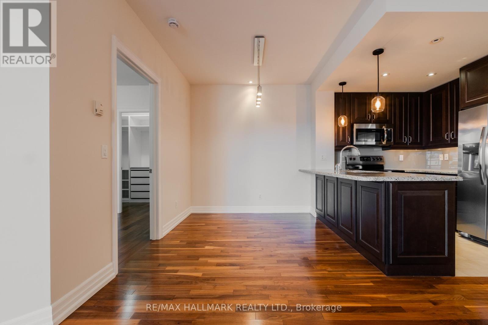 A kitchen with dark wood cabinets and a white countertop.