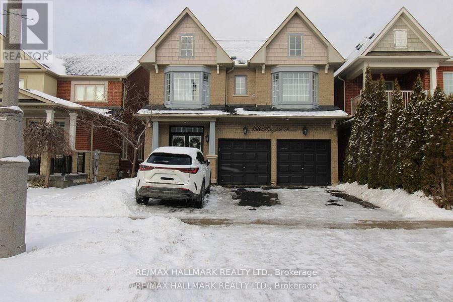 A white car is parked in front of a house with a snowy driveway.