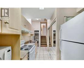 A kitchen with a white refrigerator, stove, and oven.
