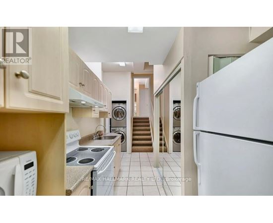 A kitchen with a white refrigerator, stove, and oven.