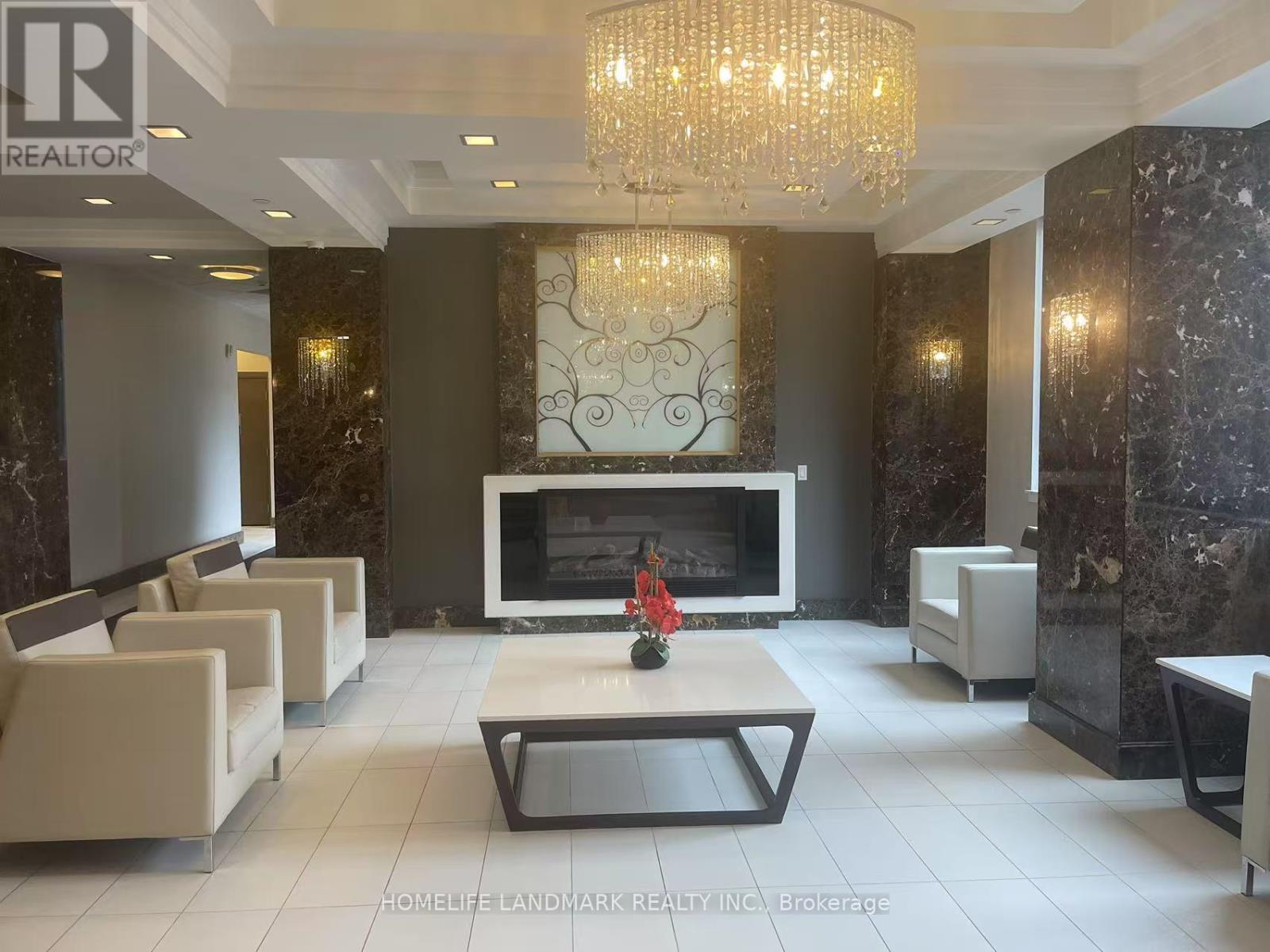 A living room with a fireplace and a chandelier.