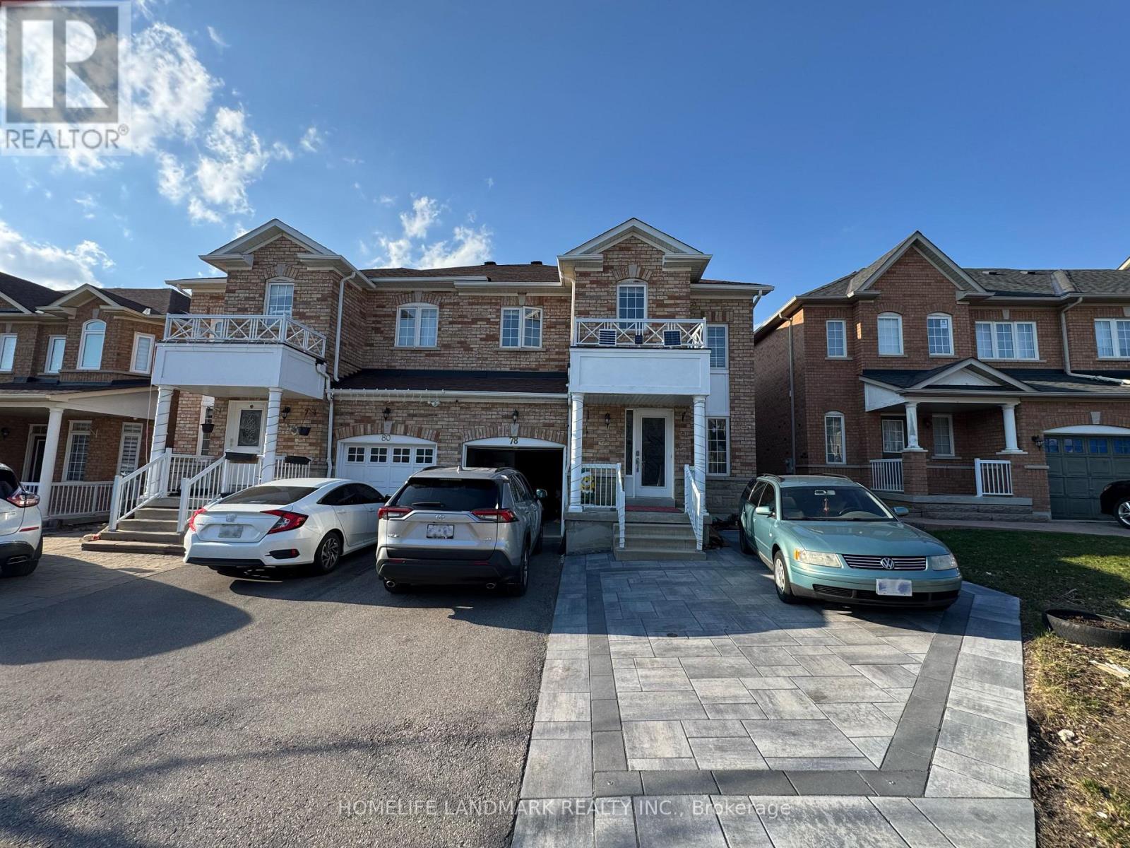 A row of houses with cars parked in front.