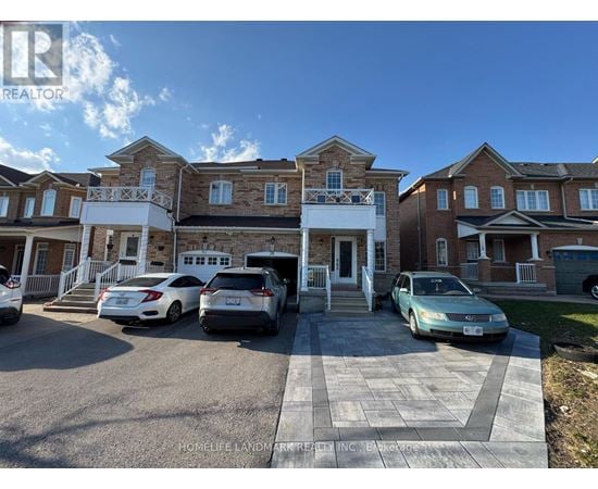A row of houses with cars parked in front.