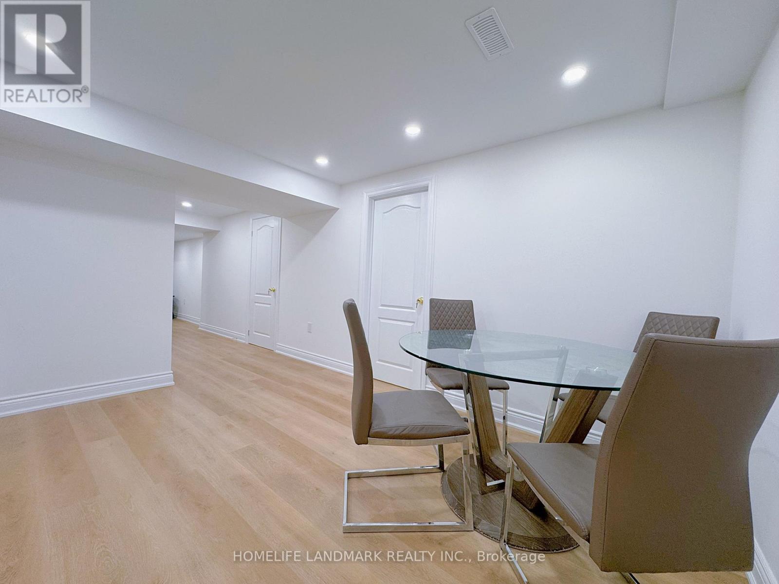 A dining room with a glass table and chairs.