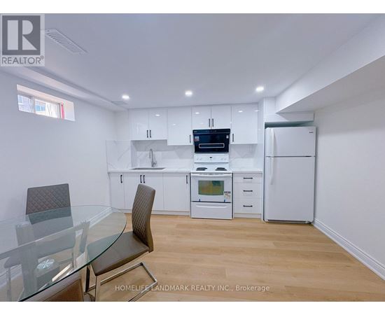 A modern kitchen with white cabinets and a glass table.