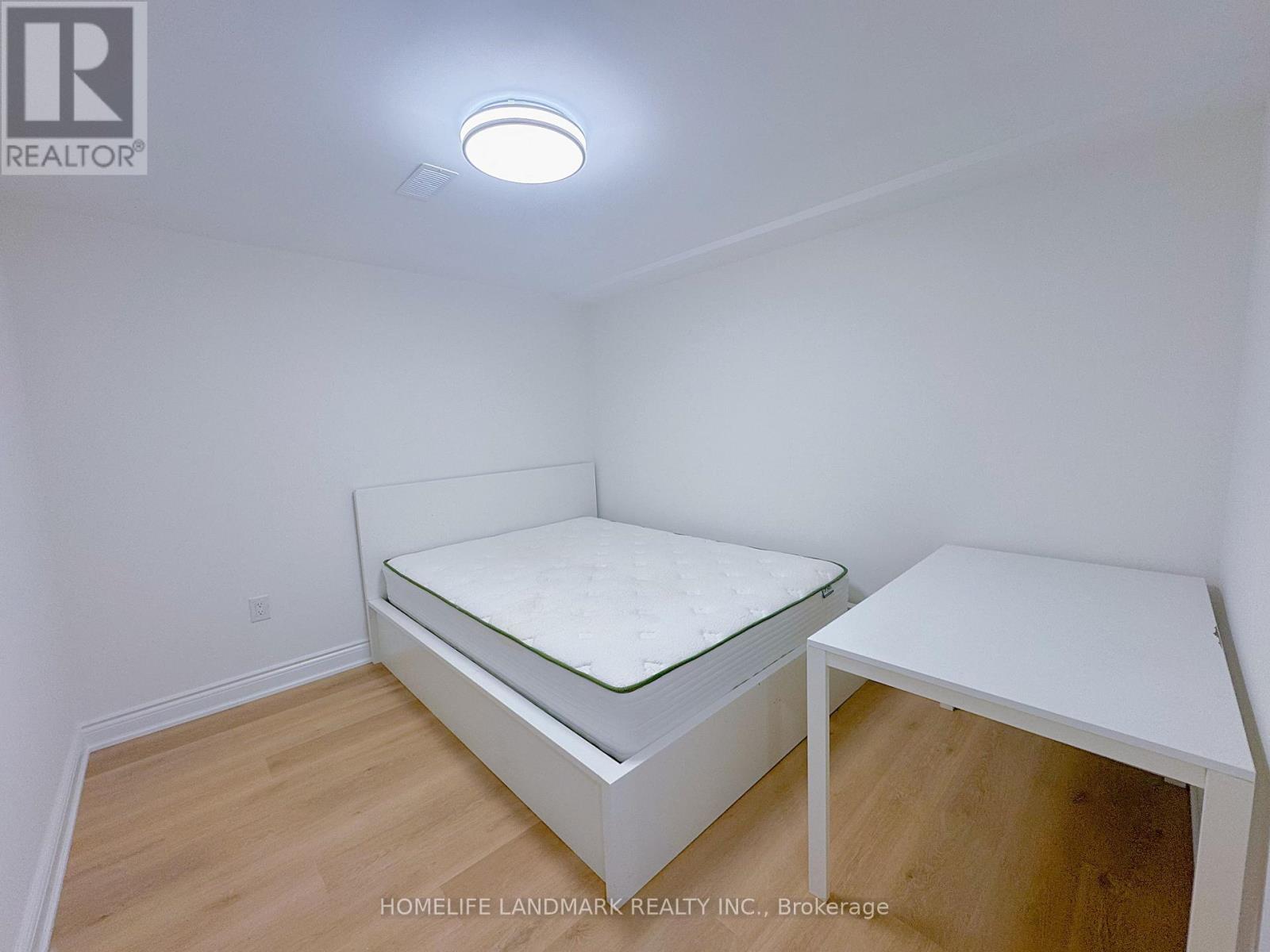 A bedroom with a bed and a desk.