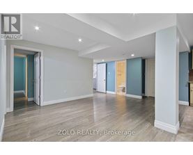 A spacious room with wooden flooring and white walls.