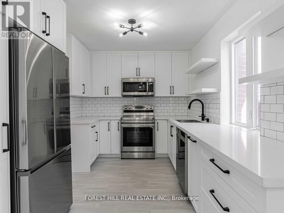 A modern kitchen with white cabinets and stainless steel appliances.