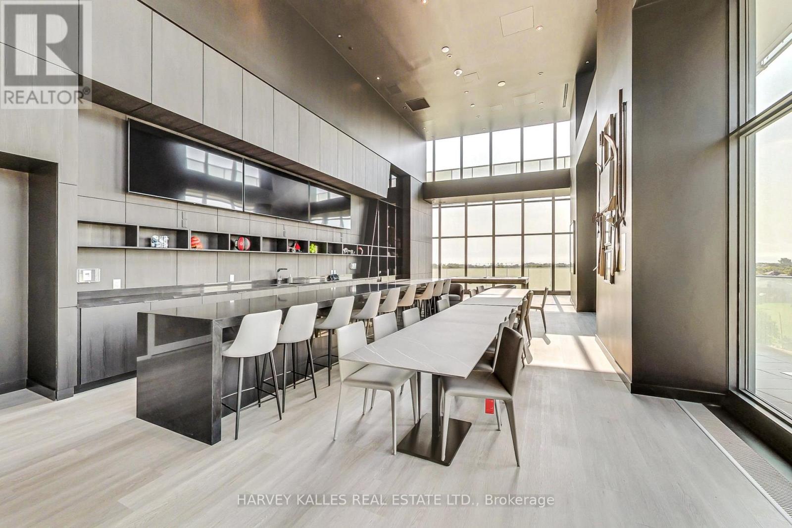 A modern dining room with a long table and chairs.