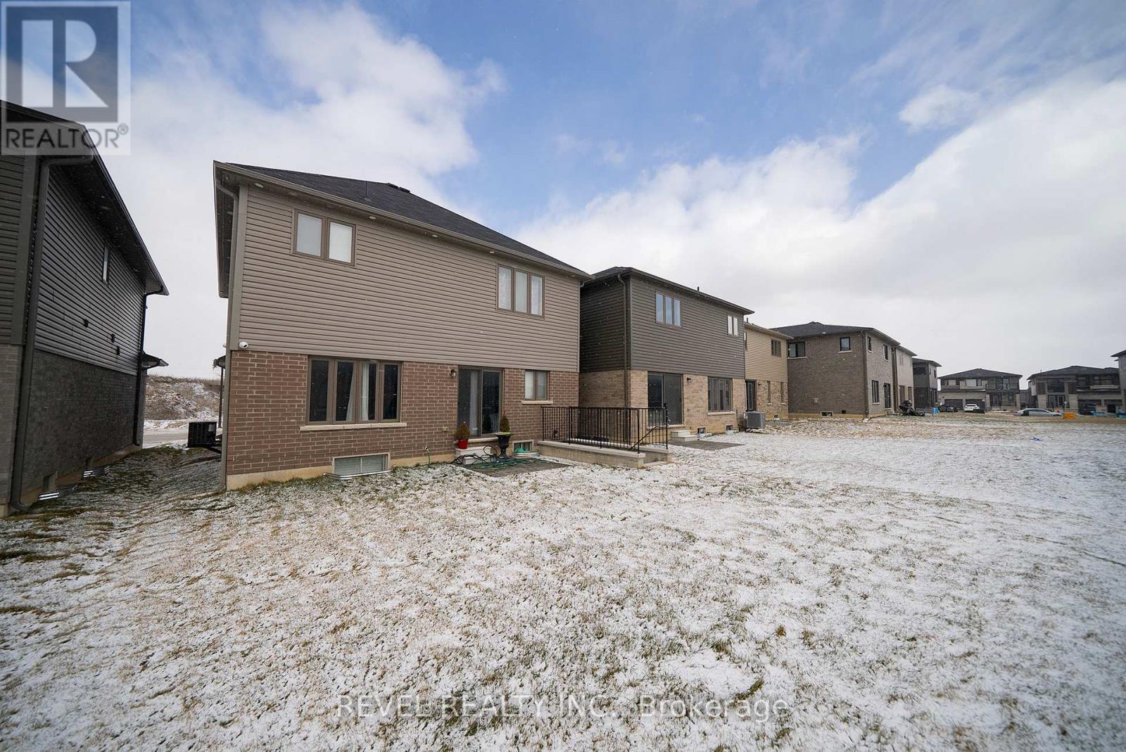 A real estate photo of a house in a snowy field.